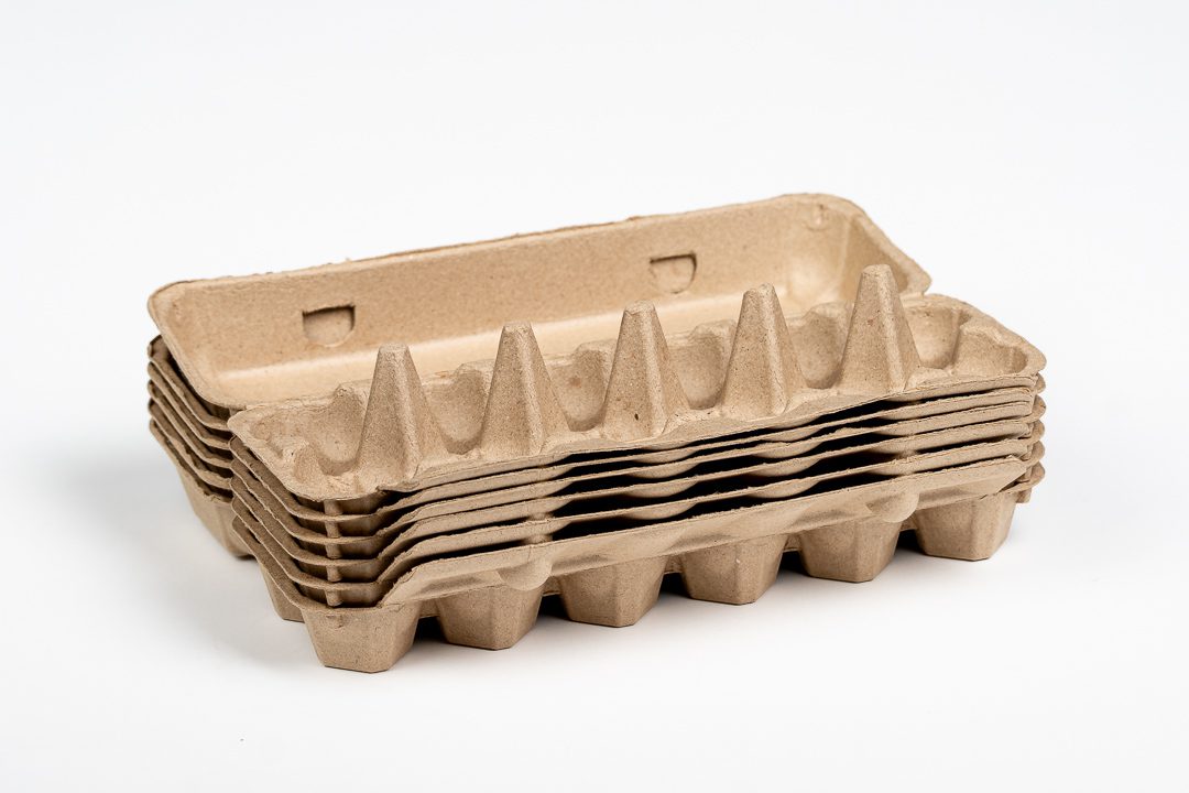 Bulk stack of natural 12-egg chicken egg cartons made from molded paper pulp